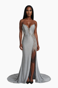 Woman wearing a silver evening gown with intricate detailing on a white background